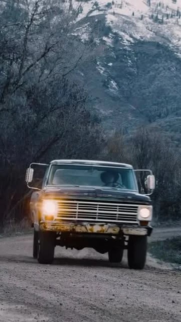 Classic Ford truck driving along a snowy trail